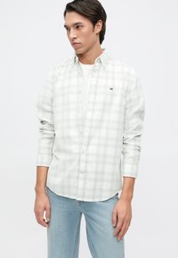 Cămașă cu carouri, button-up, în gri deschis și alb, cu un model discret de pătrățele. Dispune de mâneci lungi și un logo mic pe piept.