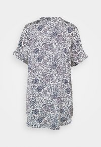 Camisa de manga corta en tejido ligero con un fondo blanco y un patrón de leopardo en color púrpura y azul marino, con un diseño holgado.