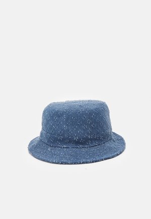 Chapeau bob en denim bleu avec une texture effilochée et de petites taches blanches sur un fond blanc.