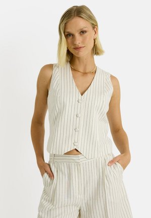 Chaleco blanco con rayas azules verticales, escote en V y cinco botones decorativos. Combinado con pantalones de cintura alta a juego, que cuentan con bolsillos.