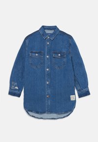 Camicia di jeans blu con maniche lunghe, chiusura frontale con bottoni, due tasche sul petto e ricamo decorativo sulla manica sinistra. Orlo arrotondato.