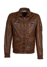 Braune Lederjacke mit Reißverschluss, zwei Seitentaschen und gerippten Bündchen. Verfügt über mehrere Abzeichen, einschließlich Flug- und Nationalinsignien.