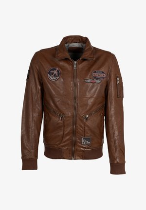 Veste en cuir marron avec fermeture éclair à l'avant, deux poches latérales et poignets côtelés. Décorée de plusieurs écussons, dont des insignias de vol et nationaux.