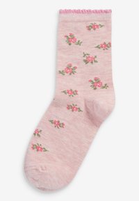 Helle rosa Baumwollsocke mit geripptem Oberteil und gewelltem Rand, verziert mit kleinen Blumenmustern in Pink und Grün.