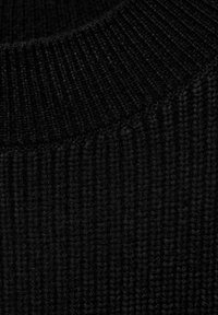 Schwarzer gerippter Strickstoff mit einer strukturierten Oberfläche und einem breiten, passenden schwarzen Halsausschnitt. Das Material scheint weich und dicht zu sein.