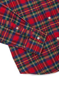 Camisa de franela a cuadros rojos con líneas verdes, azules, amarillas y blancas; puños abotonados; textura suave; dobladillo redondeado.