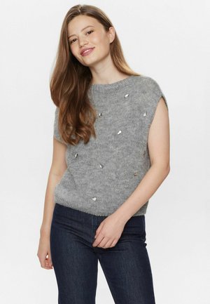 Gray, short-sleeve sweater with a coarse texture, featuring metallic accents scattered across the front. Worn with dark jeans.