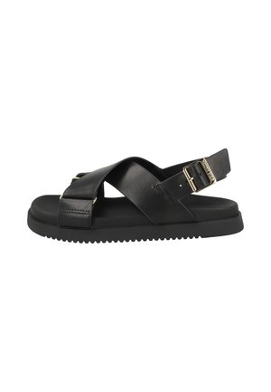 Black sandal with crossed leather straps, adjustable gold buckle on ankle strap, cushioned sole, and grooved rubber outsole.