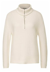 Pull en maille côtelée blanche avec un col montant et un décolleté zippé. Tissu texturé et manches longues, avec une coupe décontractée.
