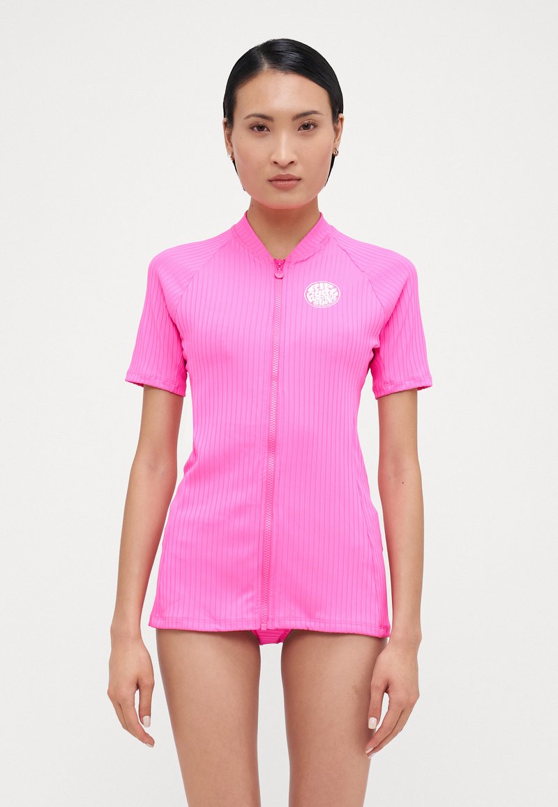 Short-sleeve, bright pink surf top, featuring a zip front, ribbed texture, and a round logo on the chest. Lightweight and fitted design.