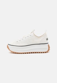 Sneaker in tela bianca con punta rotonda, design con lacci, suola bianca elevata e suola di trazione zigzag marrone. Branding discreto sul tallone.