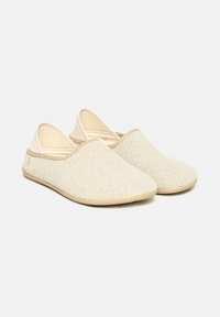 Beige slip-on slippers with a textured fabric upper and soft beige sole, designed for indoor use.