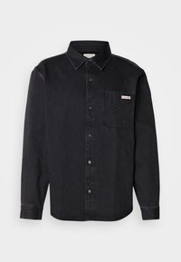 Black denim button-up shirt with a pointed collar, long sleeves, single chest pocket, and a small brand label on the pocket.