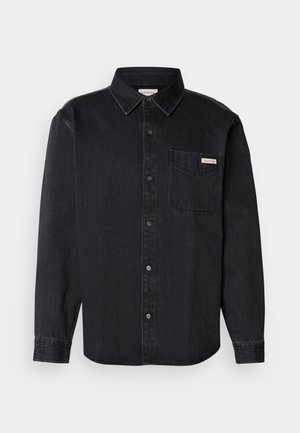 Svart denimskjorta med knappar, spetsig krage, långa ärmar, en bröstficka och en liten märkesskylt på fickan.