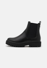Black leather ankle boots featuring elastic side panels, a pull tab, and a chunky rubber sole with a textured tread pattern.