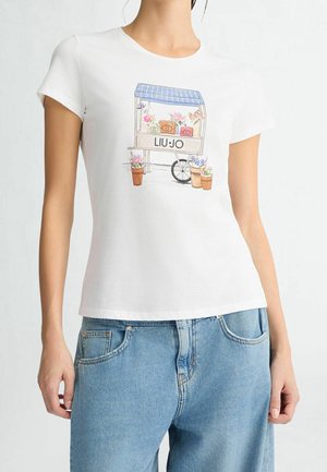 T-shirt blanc avec une illustration colorée d'un chariot à fleurs et le texte "LIU JO", porté avec un jean denim bleu clair.