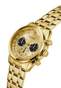 Montre Guess en ton or avec un cadran rond, trois sous-cadrans et un bracelet à maillons. La montre comporte des accents noirs et des fonctions chronographe.