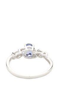 Hopea sormus, jossa on soikea vaaleanvioletti kivi, yksityiskohtainen filigraanimuotoilu rengasta ympäröivällä osalla, sileä kiillotettu pinta ja pyöristetyt reunat.