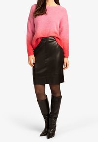 Un pull dégradé fuchsia à rose avec des manches longues, associé à une jupe crayon en cuir noir et des bottes noires à talons pointus hautes jusqu'aux genoux.