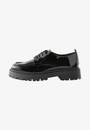Scarpe lace-up in vernice nera con una soletta nera chunky e punta arrotondata, caratterizzate da una superficie liscia e dettagli decorativi minimi.