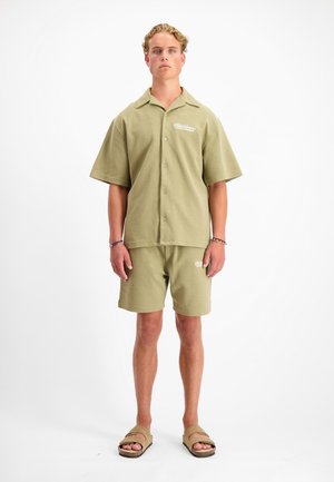 Olijfgroene korte mouwen overhemd met knopen en bijpassende shorts van zachte stof, met geborduurde logo-accenten en een relaxte pasvorm.