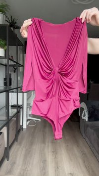 Magentafarbenes Langarm-Bodysuit mit tiefem V-Ausschnitt, drapiertem Vorderteil und strukturiertem Stoff. Verfügt über eine glatte Oberfläche und eine figurbetonte Silhouette.