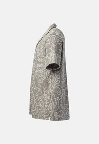 Blazer gris à manches courtes avec des motifs floraux blancs complexes et des volutes, un col et une coupe droite, vu de profil.