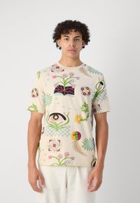 Short-sleeve cotton t-shirt in cream with vibrant floral and abstract patterns in pink, green, yellow, and blue; relaxed fit and round neck.
