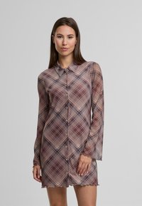 Rochie din flanel cu mâneci lungi, în tonuri de mauve stins și bej, având închidere cu nasturi în față, tiv ondulat și o țesătură ușoară și transparentă.