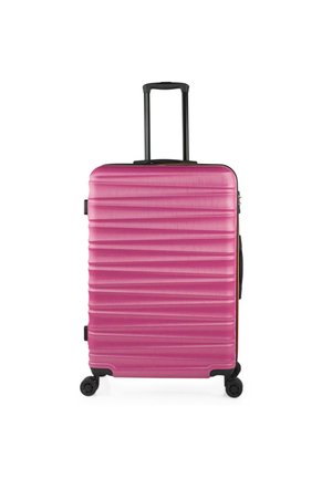 Maleta rígida rosa con textura acanalada, asa retráctil y cuatro ruedas para facilitar el desplazamiento. Cuenta con un asa lateral para un fácil levantamiento.