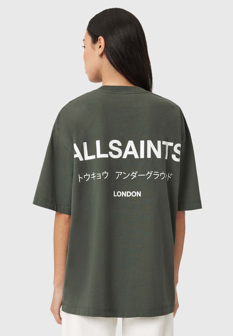 Oliivinvihreä ylikokoinen t-paita, jossa valkoiset tekstit "ALLSAINTS" ja "LONDON". Pyöreä pääntie ja lyhyet hihat, valmistettu pehmeästä puuvillasta.
