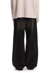 Laza fekete farmernadrág texturált felülettel, magas derékrésszel és egyedi oldalsó varrásokkal. A hátsó zsebek láthatóak és varrottak.