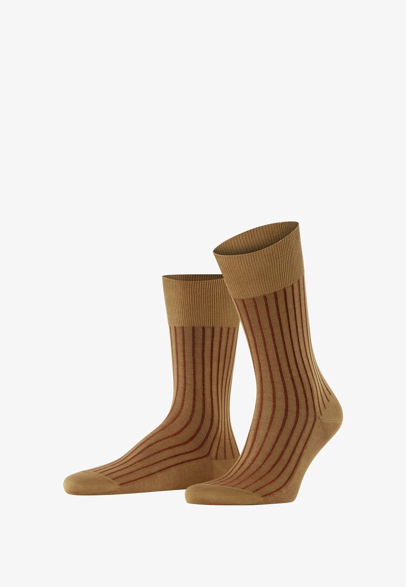 Beige Socken mit vertikalen roten Streifen, die gerippte Bündchen und glattes Material zeigen. Nebeneinander auf einem schlichten Hintergrund angeordnet.