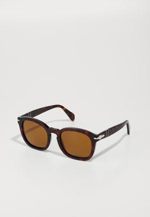 Schildpatt-Sonnenbrille mit braunen Gläsern, quadratischen Rahmen, silbernen Akzenten an den Bügeln und glatter Kunststoffoberfläche.