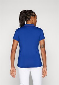 Polo shirt blu con colletto classico, maniche corte e vestibilità slim. Presenta un bordo rosa sul colletto e una texture di tessuto liscia.