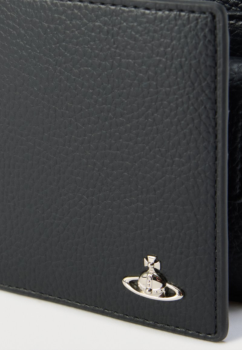 Cartera de cuero negro texturizado con un detalle de logo en hardware plateado. Costuras suaves a lo largo de los bordes y un diseño estructurado.