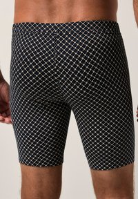 Pantaloni corti aderenti blu navy con motivo a diamante in crema, realizzati in tessuto elasticizzato. Presentano una vita elastica per il comfort.