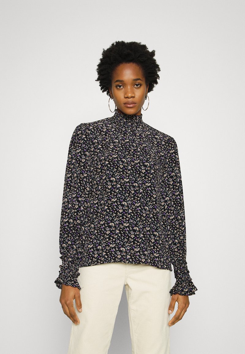 Blusa preta floral com gola alta, mangas longas e punhos franzidos. Apresenta padrões florais multicoloridos em tecido suave.
