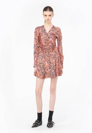 Robe à manches longues avec un imprimé zèbre rose et noir, dotée d'un devant à boutons et d'une taille cintrée. Assortie avec des chaussettes et des chaussures noires.