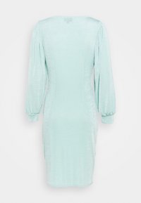 Robe ajustée vert menthe avec une texture douce, manches longues bouffantes et un col rond, se terminant à une longueur au genou.