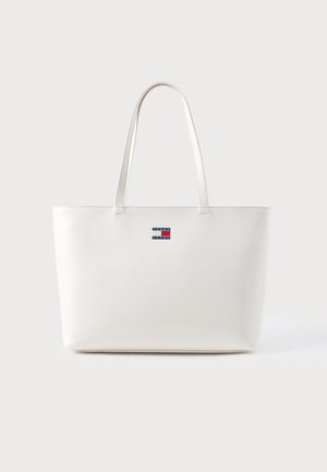 Sac cabas rectangulaire blanc avec des anses fines et un petit logo Tommy Jeans centré près du haut à l'avant.