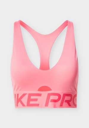 Lyserød sports-bh med dyb V-udskæring, racerback-design og bredt bånd med teksten 'NIKE PRO' i fed skrift. Glat, elastisk materiale.