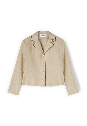 Blazer beige texturé à manches longues avec quatre boutons, bordure marron foncé sur le col et le devant, et une broche décorative sur le revers gauche.
