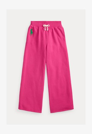Rožnate široke trenirke iz bombaža z elastiko v pasu, belim vrvico za zategovanje in zelenim vezenim logotipom na levi strani.