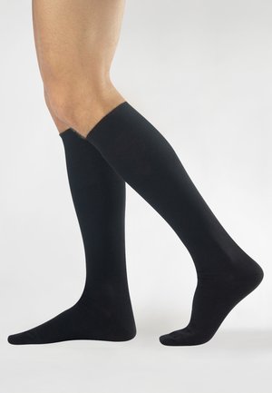 Calze nere al ginocchio con un polsino a coste, texture liscia e design aderente, adatte per un abbigliamento casual o formale.