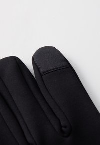 Zwarte stoffen handschoenen met een gladde textuur, voorzien van een elegant ontwerp en versterkte stiksels op de vingertoppen.