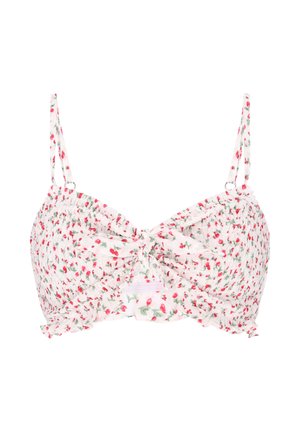Hvid cropped top med tynde stropper, lille rødt blomsterprint, rynket stof og en knyttet detalje foran.