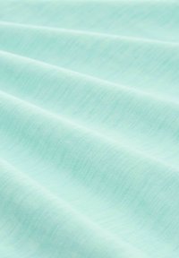 Tejido suave, de un azul claro con una sutil textura ribeteada horizontal y suaves pliegues que crean un patrón ondulante en la superficie.