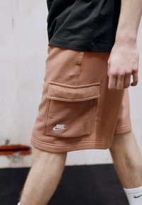 Nike Sportswear CLUB CARGO - Calças de fato de treino - mineral clay/white