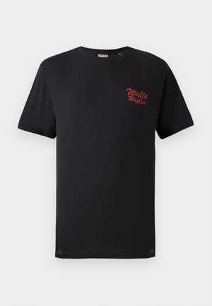 T-shirt de algodão preto com mangas curtas e decote redondo, com texto bordado em vermelho "Walt's Waffles" na área do peito esquerdo.
